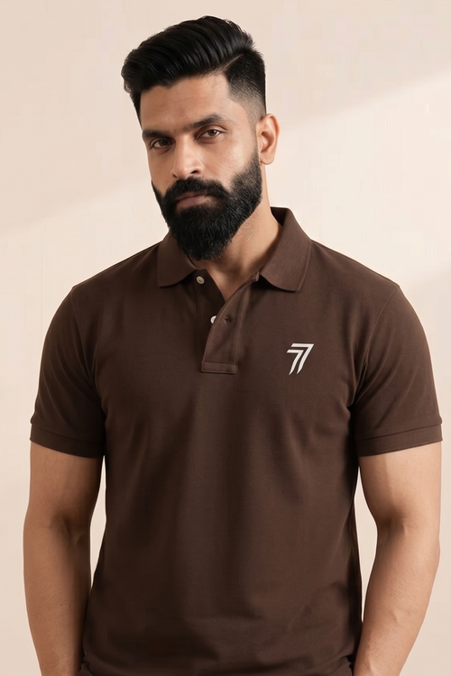 Man wearing a brown polo shirt with a logo on a beige background